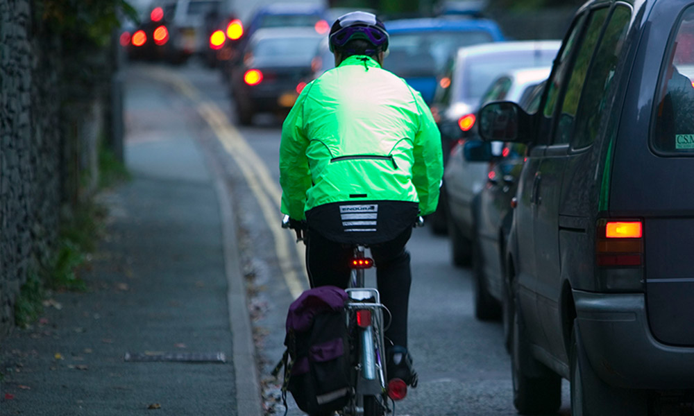 Cyclist commuting through a traffic jam, Ambleside, Cumbria, UK © Global Warming Images / WWF